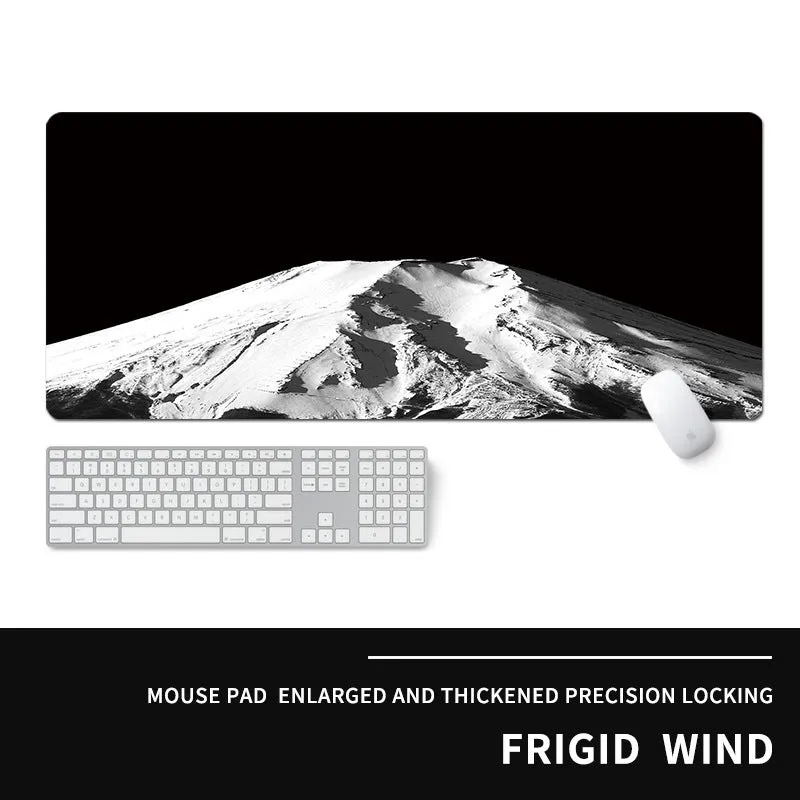 Oversized natural rubber mouse pad with printed graphic and integrated wrist support on a desk.