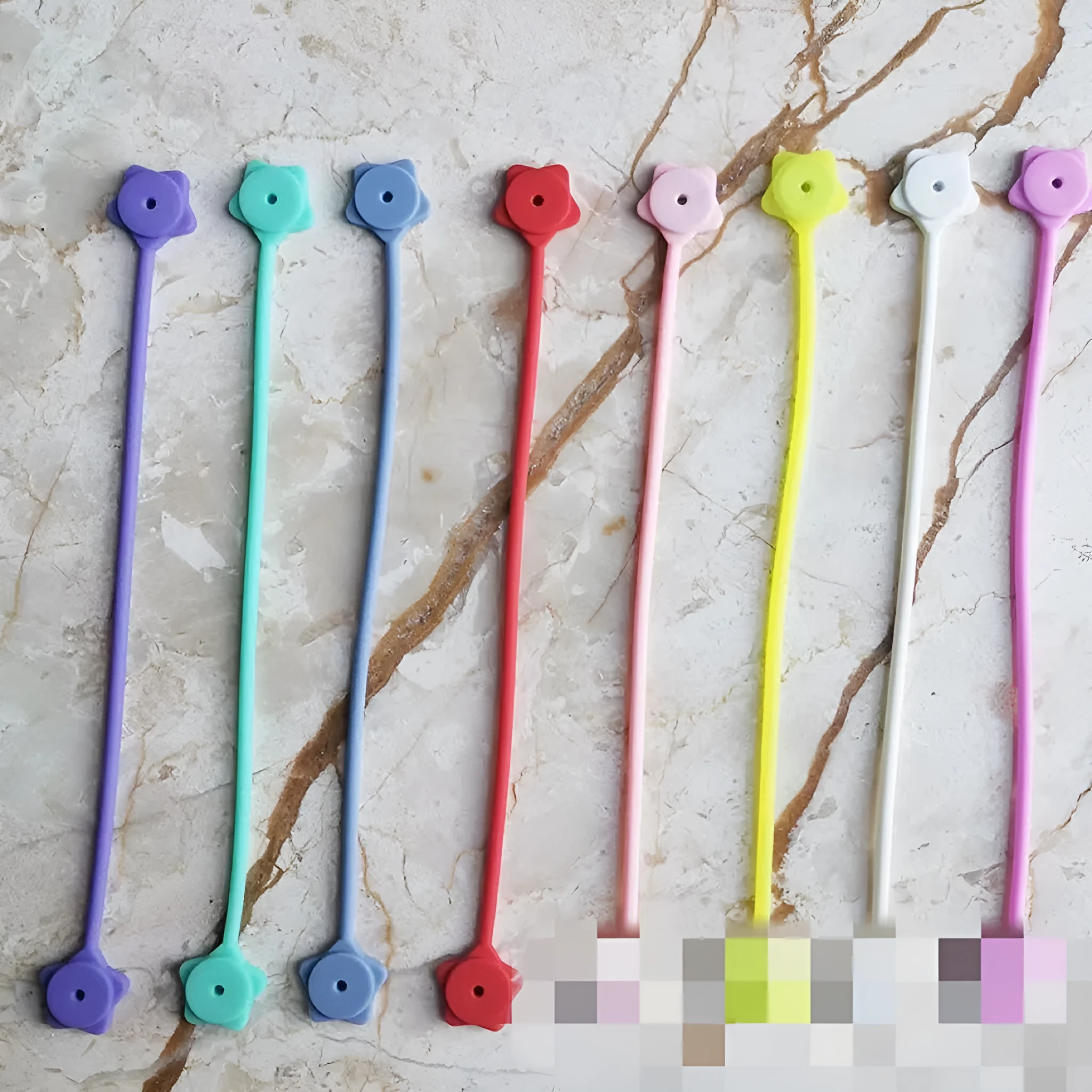 Purple silicone wire winder with magnet for organising headphone and computer cables.