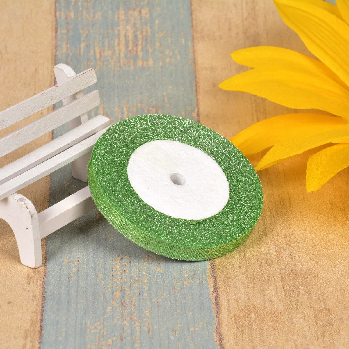 Close-up of green onion patterned polyester ribbon with metallic wire accents on a 25-yard roll.