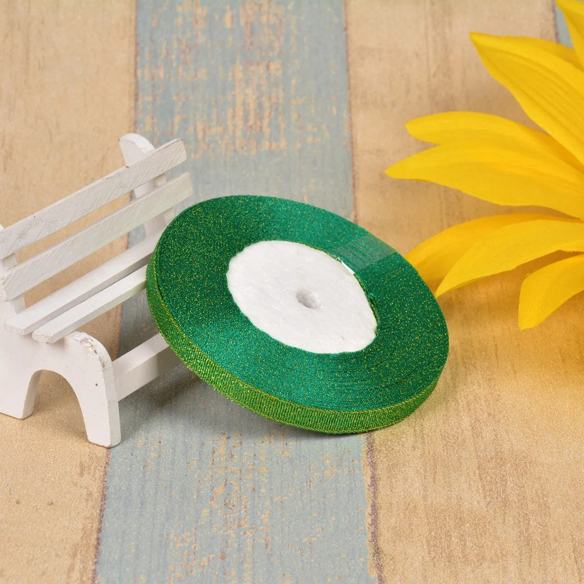 Close-up of green onion patterned polyester ribbon with metallic wire accents on a 25-yard roll.