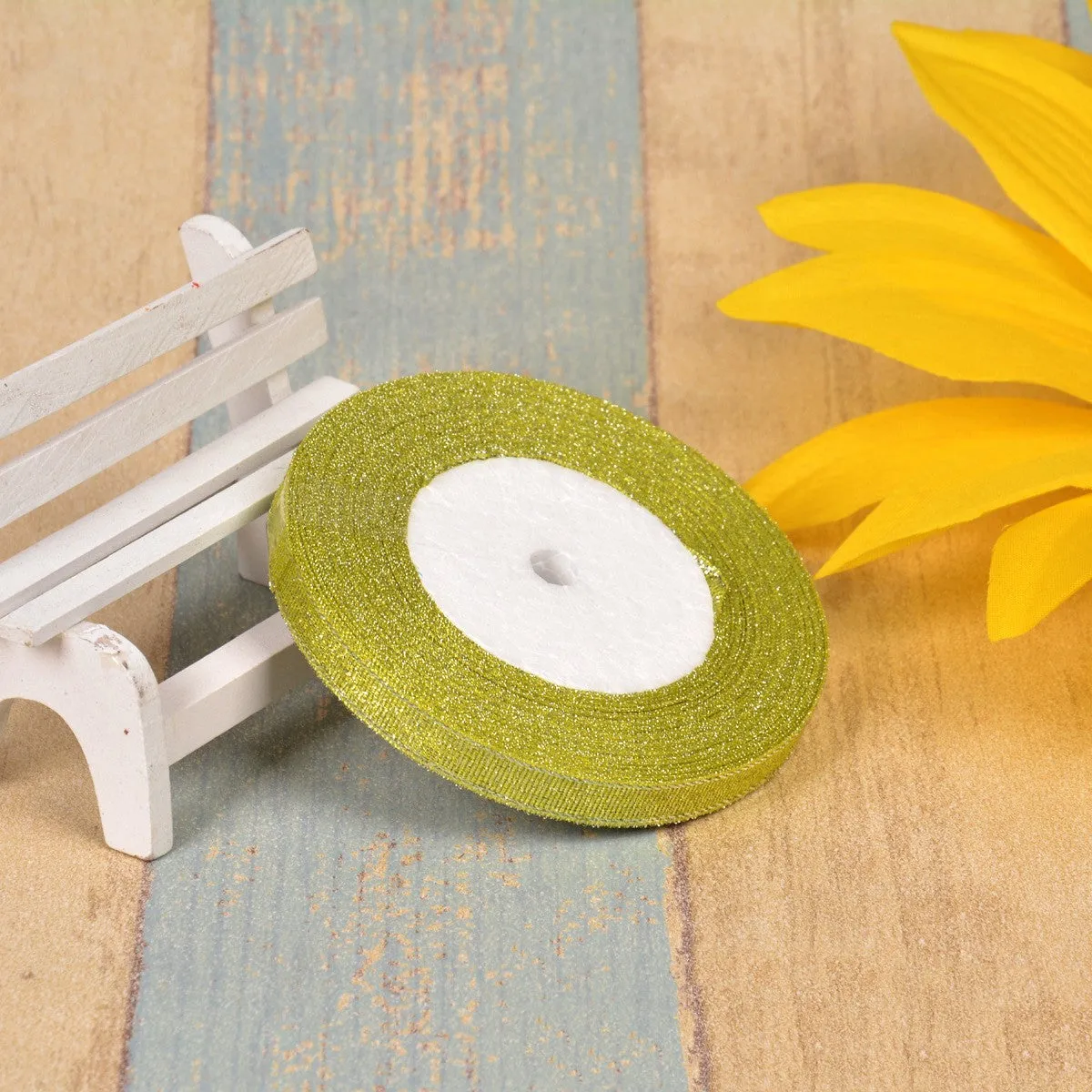 Close-up of green onion patterned polyester ribbon with metallic wire accents on a 25-yard roll.