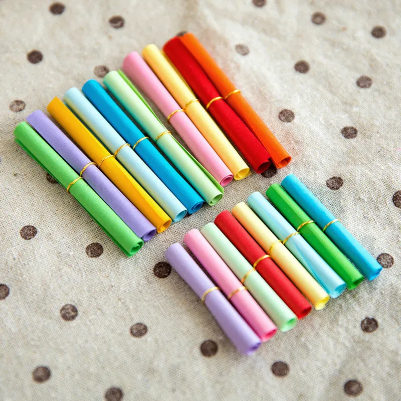 Assorted colourful mini paper scrolls with eyelets for drift bottle messages in sizes 3x7cm, 4x7cm, 7x7cm, and 5x5cm.