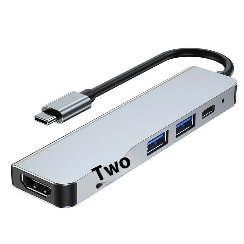 Silver aluminium USB-C expansion dock showing six ports including HDMI, USB 3.0, USB-C PD charging, and card readers