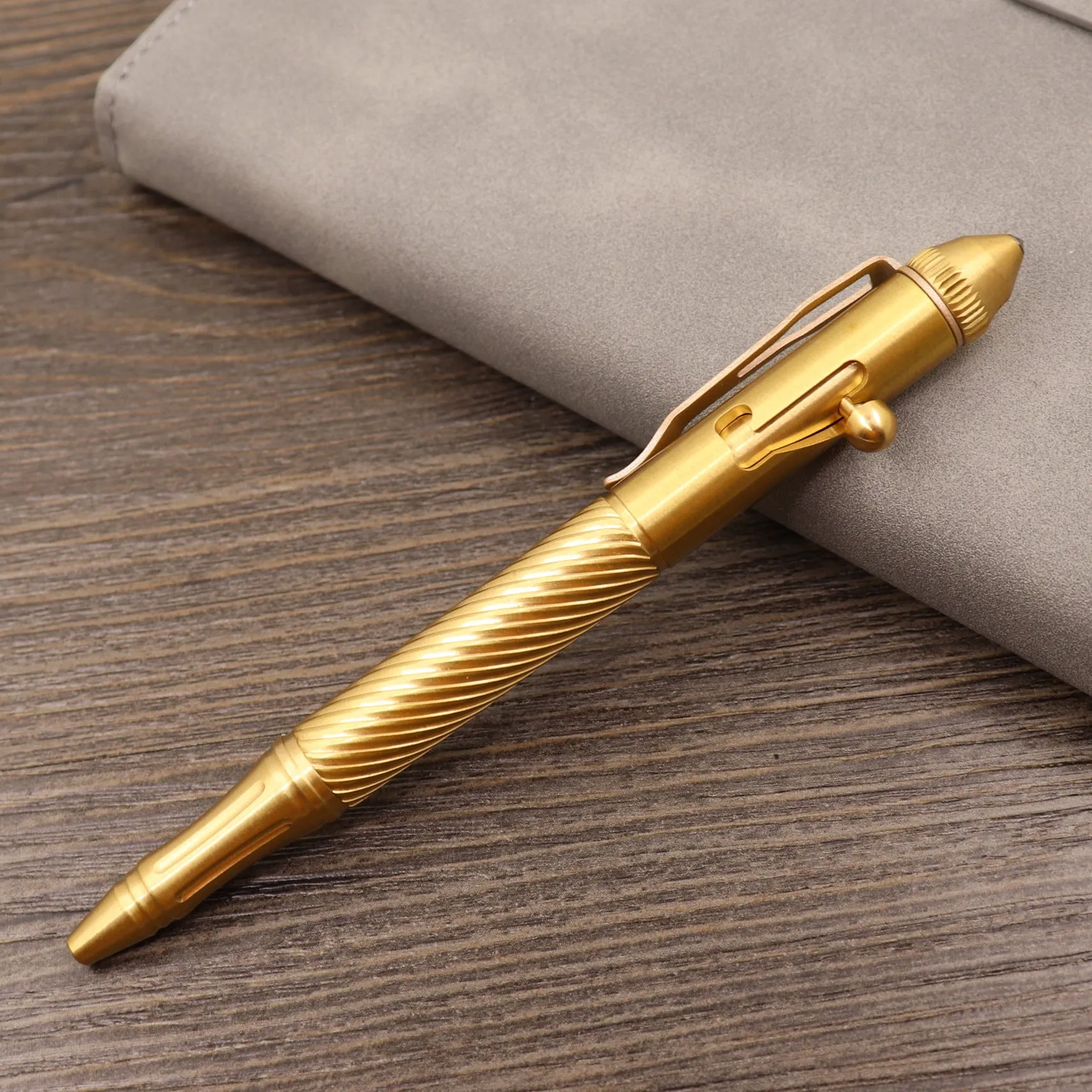 Brass tactical pen with six-ring press mechanism and cylindrical design in metallic finish