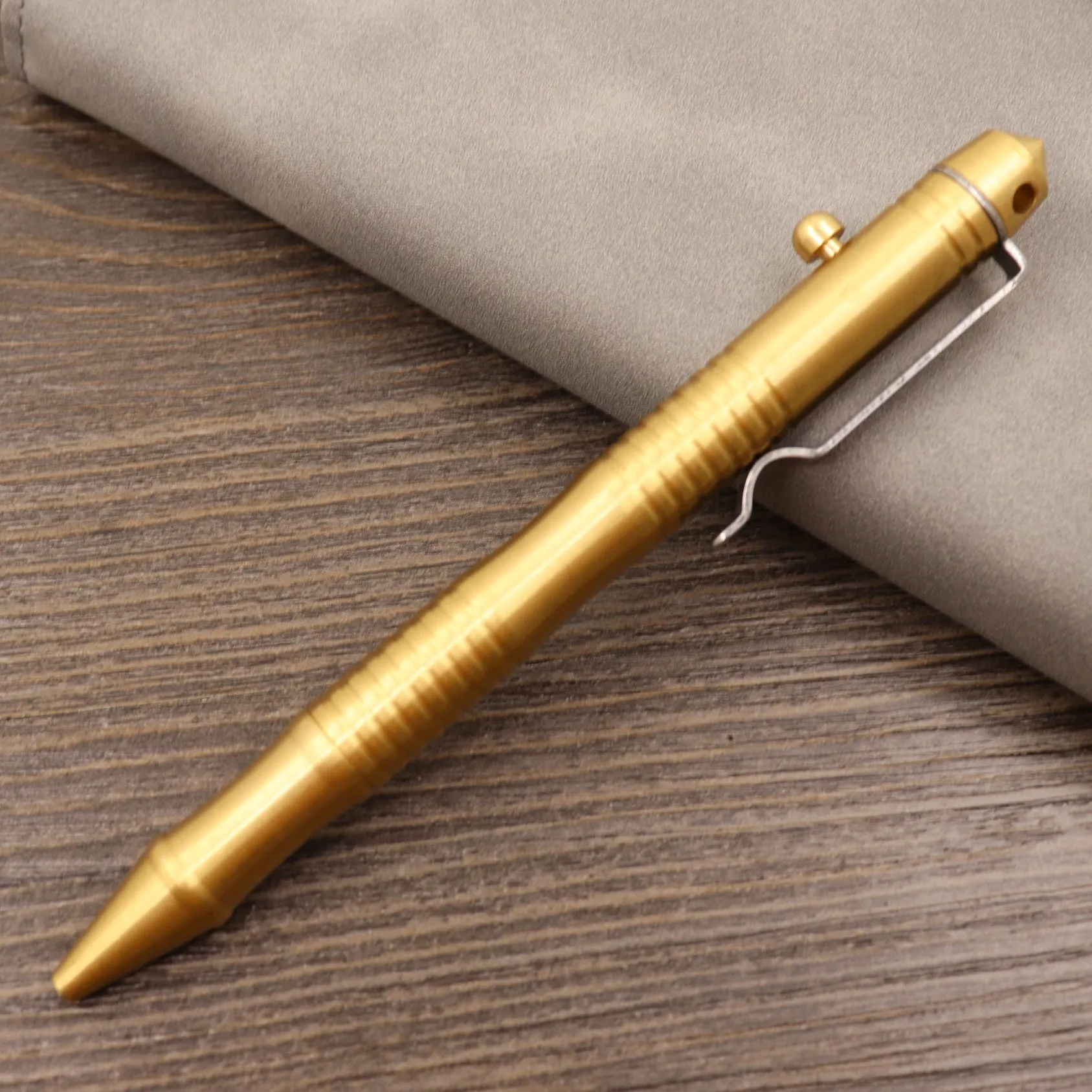 Brass tactical pen with six-ring press mechanism and cylindrical design in metallic finish