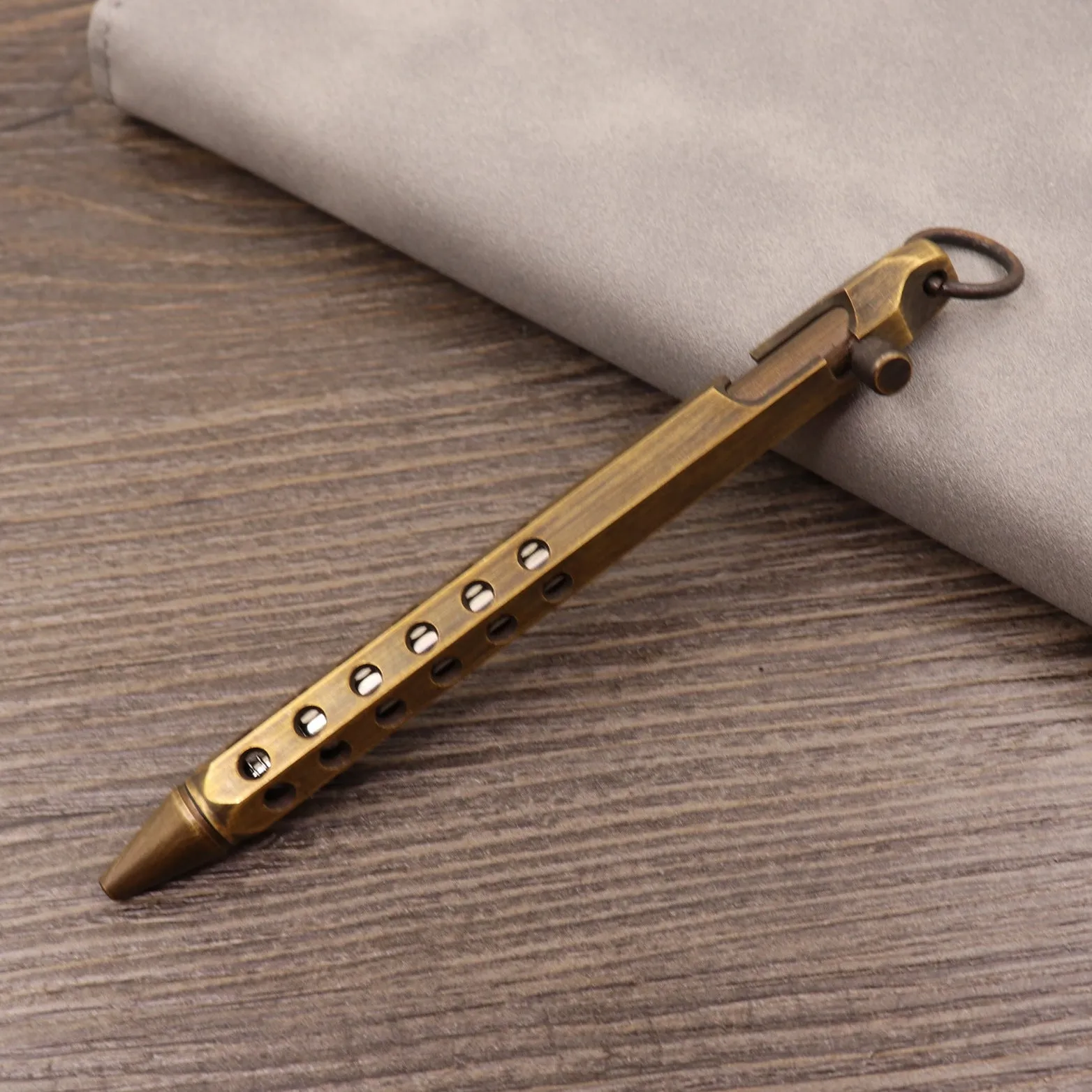 Brass tactical pen with six-ring press mechanism and cylindrical design in metallic finish