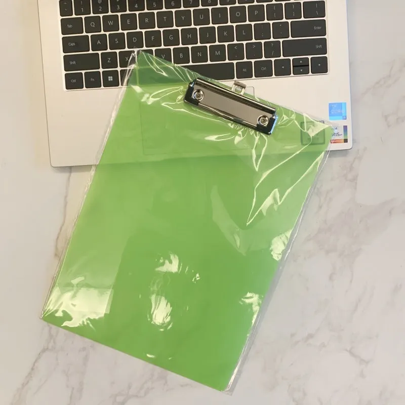 Clear A4 plate holder with metal clip and transparent writing pad in blue colour on a desk.