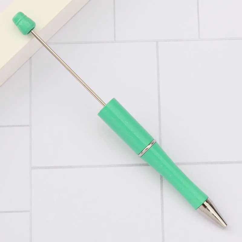 Colourful spinning ballpoint pen with plastic beads on a white background.