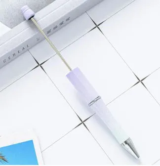 Colourful spinning ballpoint pen with plastic beads on a white background.
