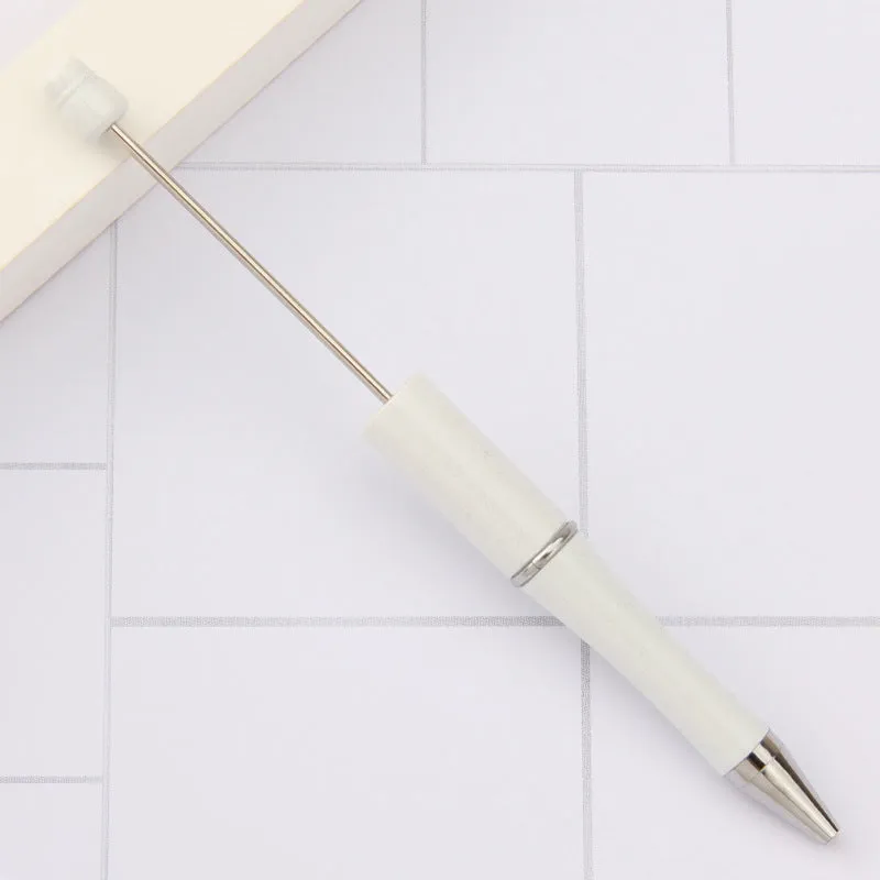 Colourful spinning ballpoint pen with plastic beads on a white background.