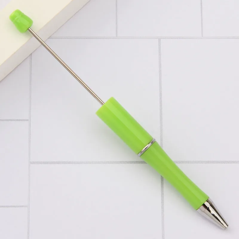 Colourful spinning ballpoint pen with plastic beads on a white background.