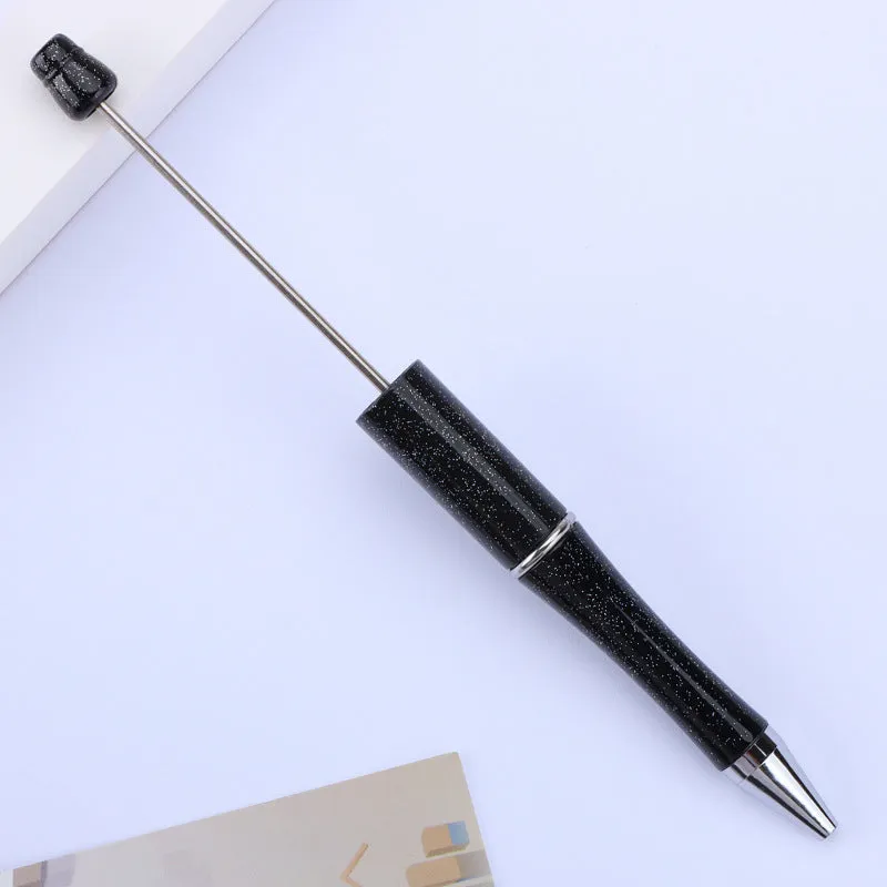Colourful spinning ballpoint pen with plastic beads on a white background.