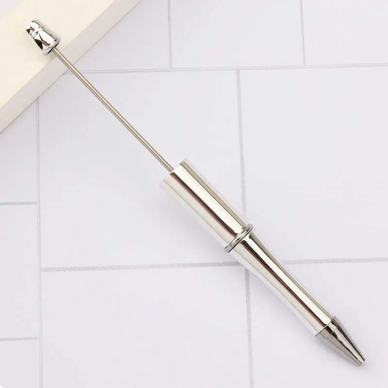 Colourful spinning ballpoint pen with plastic beads on a white background.