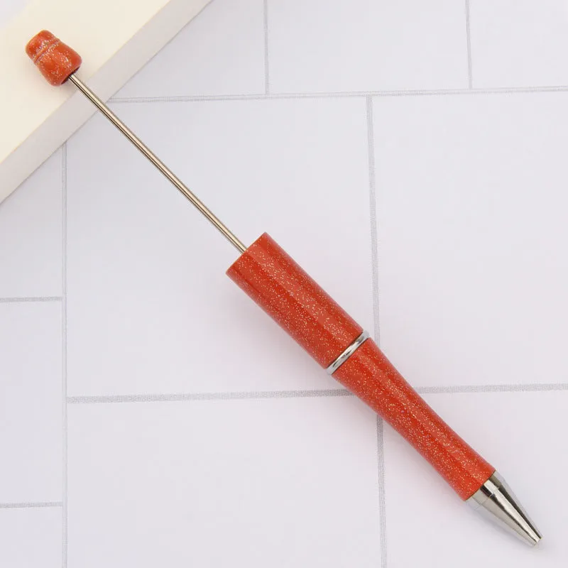 Colourful spinning ballpoint pen with plastic beads on a white background.