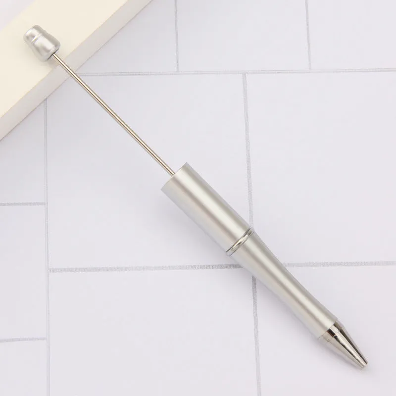 Colourful spinning ballpoint pen with plastic beads on a white background.
