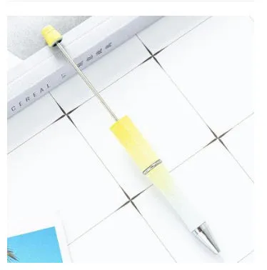 Colourful spinning ballpoint pen with plastic beads on a white background.