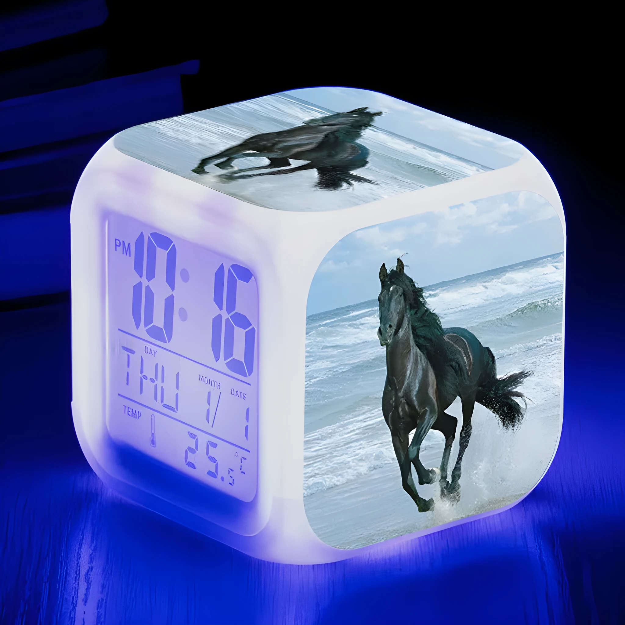 Small square cartoon-style LED alarm clock with colour-changing light feature on a table.