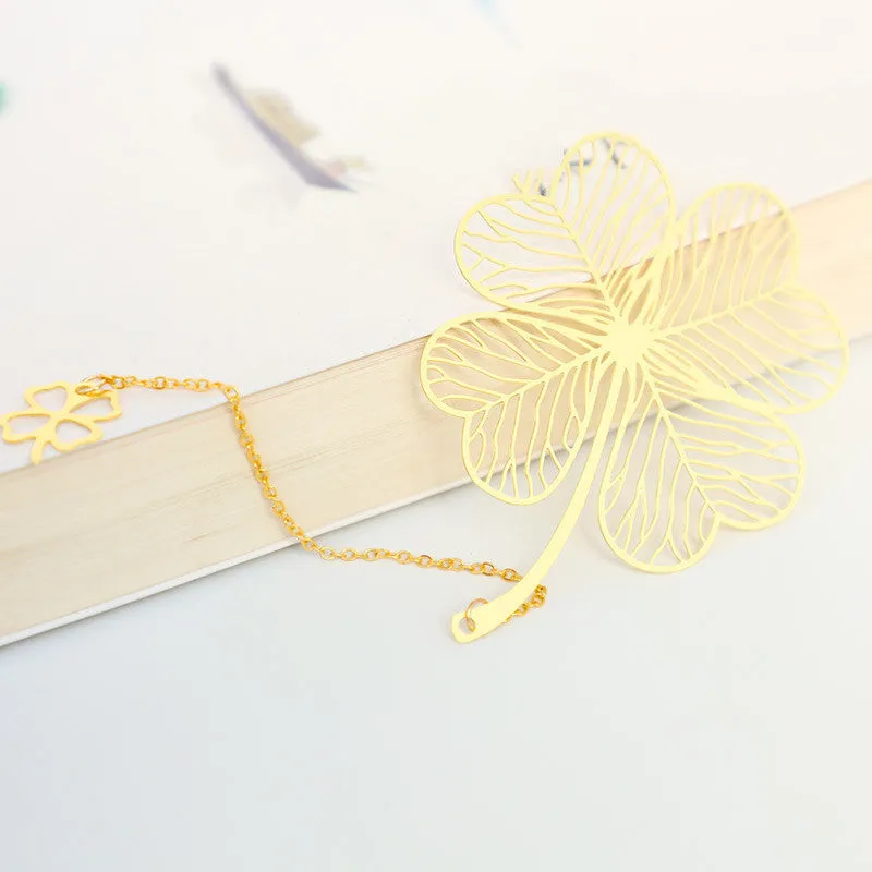 Detailed brass bookmark with hollow maple leaf pendant and rose gold tassel on a book page.