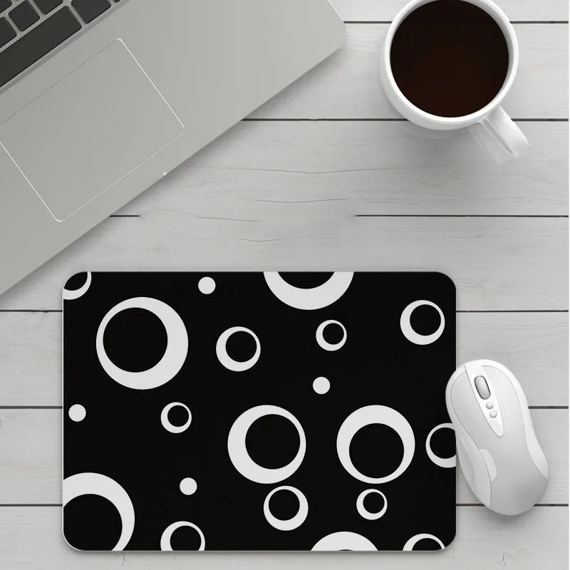 Thick custom cartoon mouse pad with colourful design on a desk, showing black seam edge