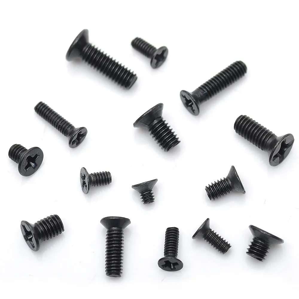 Black flat head M1.4 x 16mm laptop screws spilt from a box, showing cross slot drive and countersunk head profile.