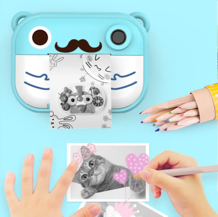 Blue digital printing camera with 2.4-inch screen showing image preview, alongside printed photo and accessories