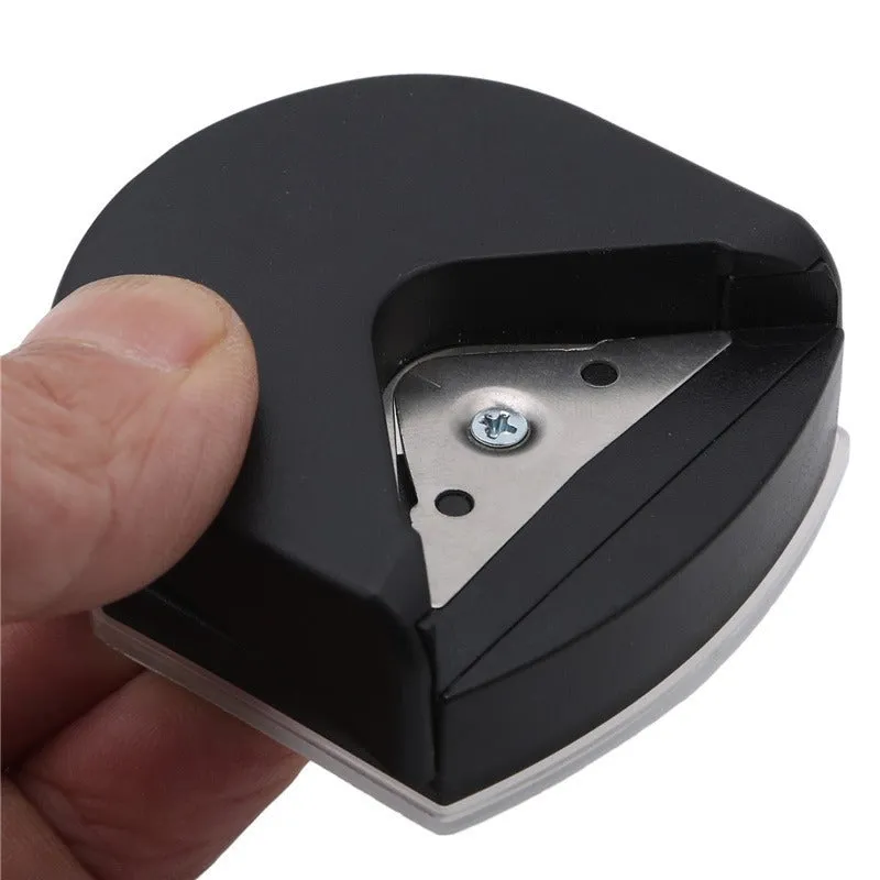 Black plastic and metal business card corner cutter on a white background.