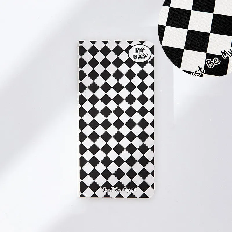 Ins style A5 grid notebook open on a desk, showing grid paper and one of twelve colourful cover designs like pineapple or checkerboard.